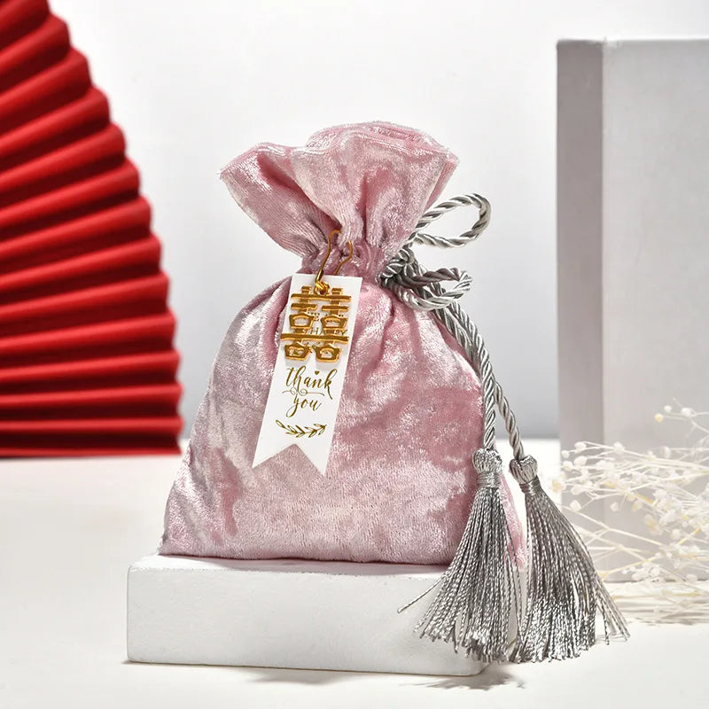 Bolsa de terciopelo con borlas y cordón de tela.