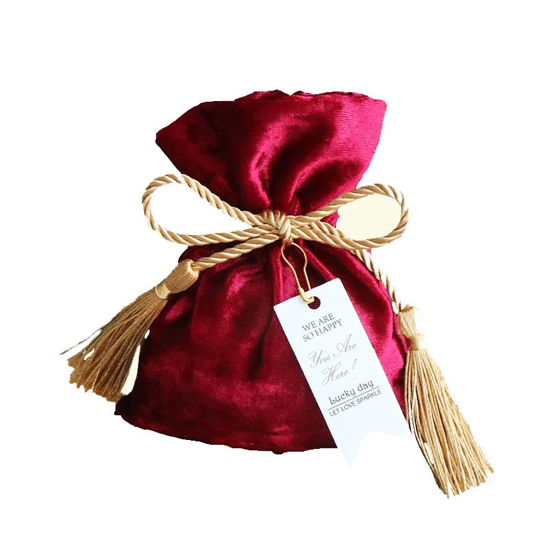 Bolsa de terciopelo con borlas y cordón de tela.