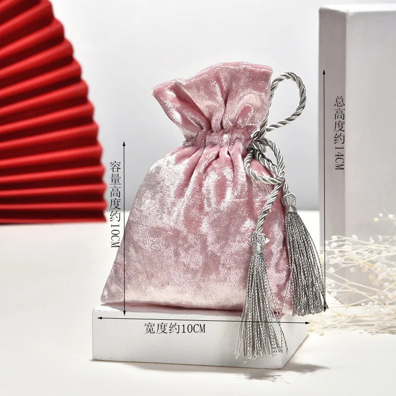 Bolsa de terciopelo con borlas y cordón de tela.